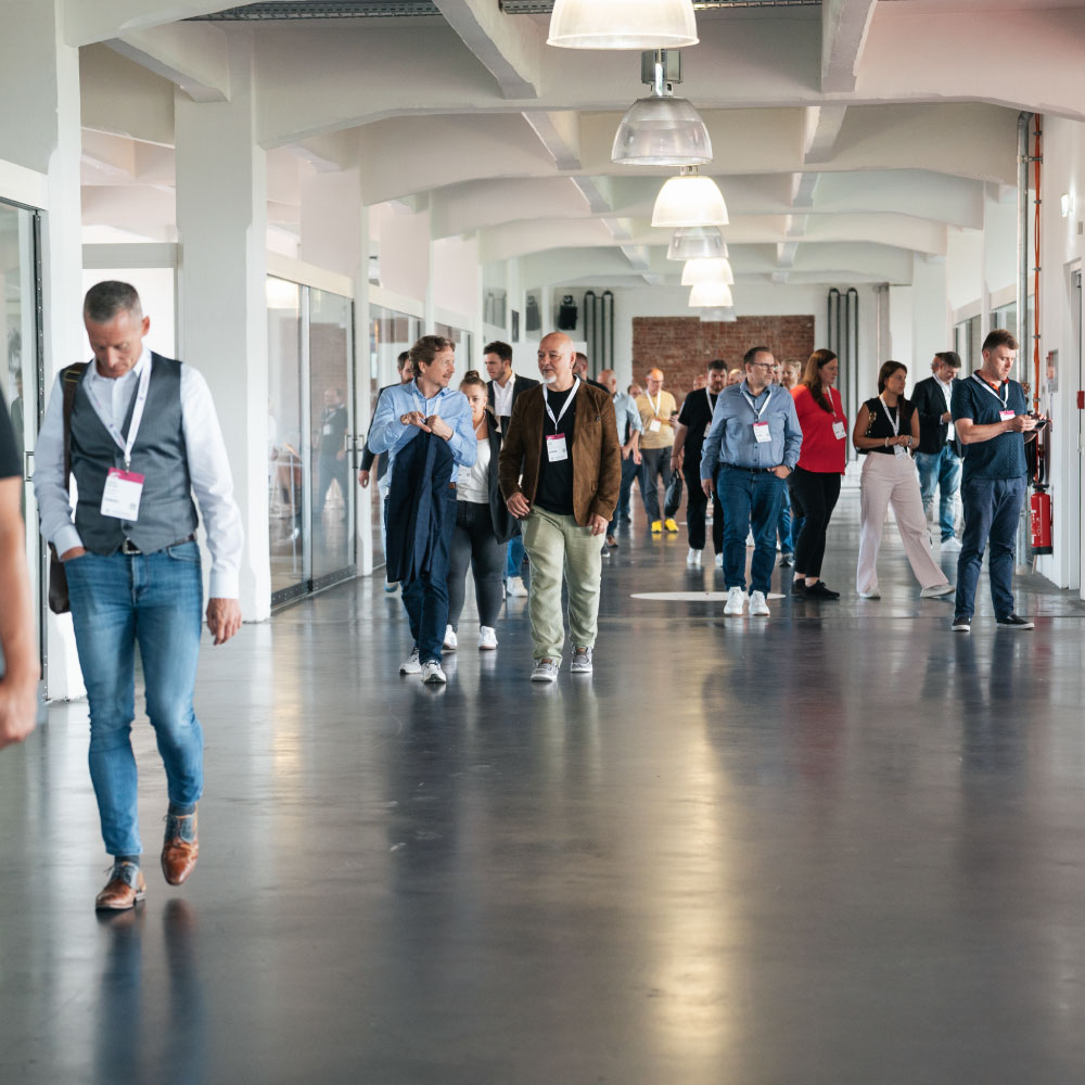 Besucherinnen und Besucher laufen durch den hellen Gang der MSP Day Location